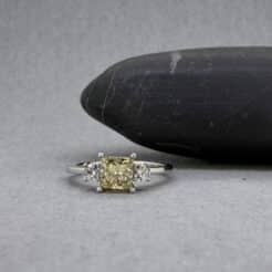 Sortija de lujo en oro blanco con diamante central amarillo intenso y brillantes laterales.