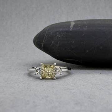 Sortija de lujo en oro blanco con diamante central amarillo intenso y brillantes laterales.
