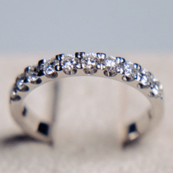 Primer plano macro de una media alianza de oro blanco de 18k mostrando el detalle de los diamantes naturales de 0.50 cts en total, resaltando la simetría del engaste y el brillo de las piedras.