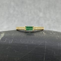 Un anillo hecho de manera artesanal con un diseño moderno pero lleno de sofisticación y lujo con una esmeralda baguette y diamantes naturales.